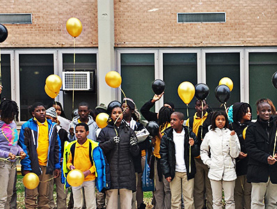 Students release balloons colored gold and black, their school colors.