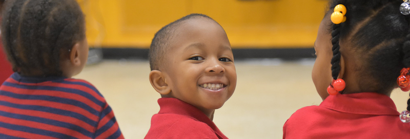 Smiling boy in classroom with other students