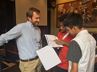 Two male students speaking to an educator