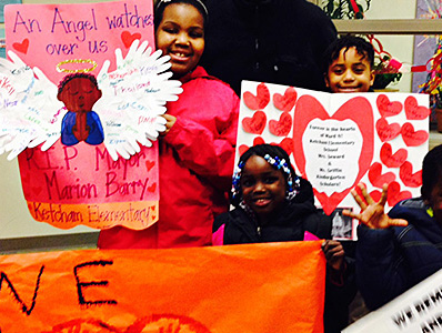 Students hold colorful signs.