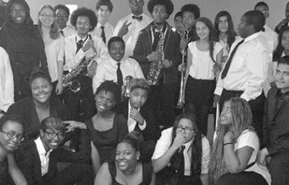 Students pose for a picture holding instruments and smiling.