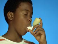 Young man with asthma inhaler Photo of young man using asthma inhaler